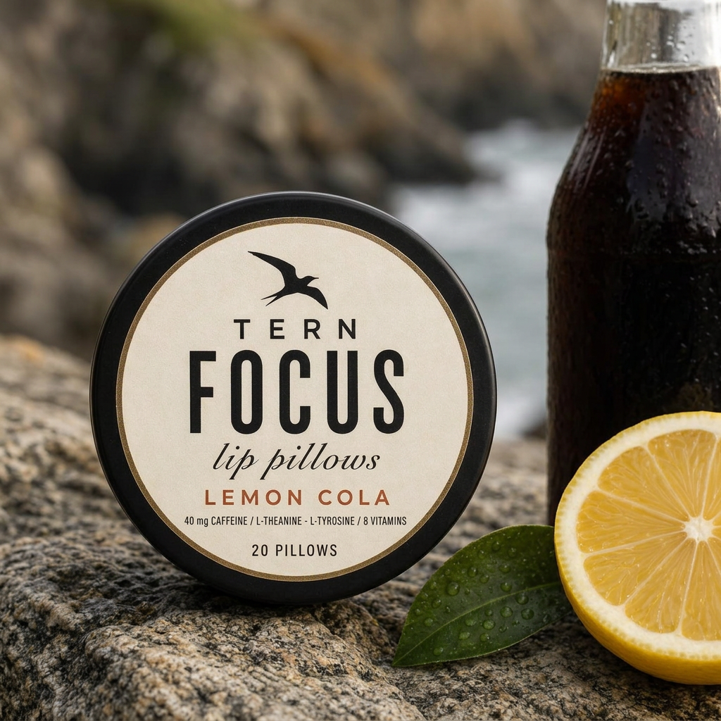 TERN FOCUS lip pillows in Lemon Cola beside a lemon wedge on coastal granite